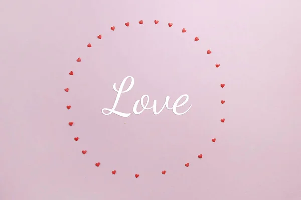 Fondo pastel rosa con círculo de pequeños corazones dulces con amor texto — Foto de Stock