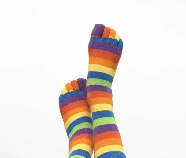 Patas femeninas en calcetines de colores elevados a la parte superior sobre un fondo blanco aislado — Foto de Stock