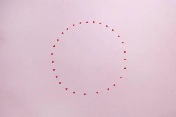 Розовый пастельный фон с кружком маленьких сладких сердец для текста — стоковое фото