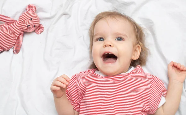 웃으면서 누워서 누워 있는 한 살짜리 소녀가 행복해 하 세요. 행복 한 모성의 개념. 위에서 본 풍경. — 스톡 사진