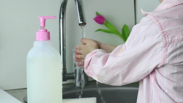 Barn ungen tvättar händerna under kranen med en speciell barngel. Mors kvinnliga händer hjälpa rulla upp ärmar. — Stockvideo