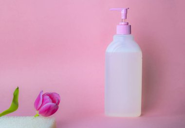 Pembe arka planda sabunu olan kadınlar için sıvı sabun. Temizleyici konsept. Samimi hijyen için. Kadınlar için yumuşak çevre dostu güzellik ürünü.