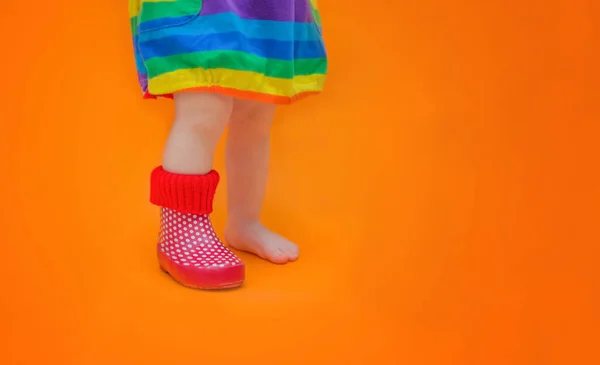 Pied d'enfant dans une botte en caoutchouc. Une jambe est nue - pieds nus. Bébé a perdu sa botte. Le concept de printemps, d'été, de coloris et les premiers pas d'un tout-petit . — Photo