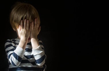Küçük beyaz tenli sarışın çocuk 3-4 yaşlarında yüzünü karanlıkta tek başına örttü ve korktu. Sosyal sorunlar, işlevsiz aileler, çocuk istismarı kavramı. Boşluğu kopyala.