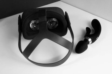 VR glasses VR helmet next to a black dildo vibrator. The concept of virtual 3D porn and the future of the porn industry. Female pleasure