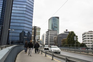 İstanbul, Türkiye - Kasım-10.2019: Levent ilçesinde yol kenarında ve gökdelenlerde yürüyen insanlar.