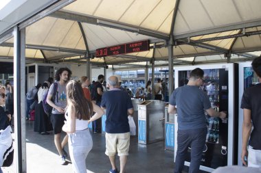 İstanbul, Türkiye - 11 Eylül 2019: Fkadikoy feribot iskelesi. Eminonu kıyısından, yolcular feribota binmek için gelirler. Öndeki işaretin üstünde saatler ve kadikoy var..