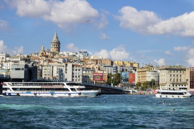 İstanbul, Türkiye - 11 Eylül 2019: Galata Köprüsü 'nün altından geçen feribot. Karaköy plajının karşısında ve yukarıda galata kulesi var..