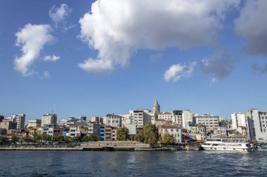 İstanbul, Türkiye - 11 Eylül 2019: Galata Köprüsü 'nün altından geçen feribot. Karaköy plajının karşısında ve yukarıda galata kulesi var..