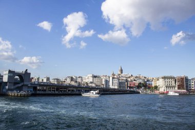 İstanbul, Türkiye - 11 Eylül 2019: Galata Köprüsü 'nün altından geçen feribot. Karaköy plajının karşısında ve yukarıda galata kulesi var..