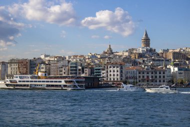 İstanbul, Türkiye - 11 Eylül 2019: Galata Köprüsü 'nün altından geçen feribot. Karaköy plajının karşısında ve yukarıda galata kulesi var..