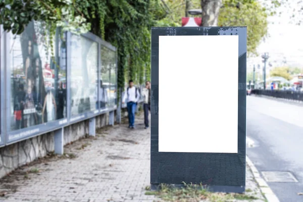 Tomma vita rektangulära skylt vid vägkanten. Till vänster kommer 2 tonåringar till fots. — Stockfoto