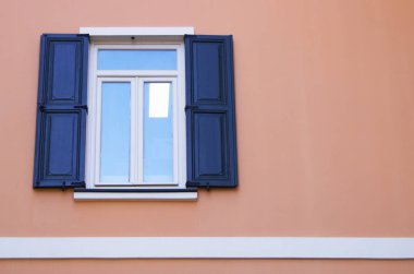 Pembe duvardaki pencere. Tahta kapılar yana açılıyor..