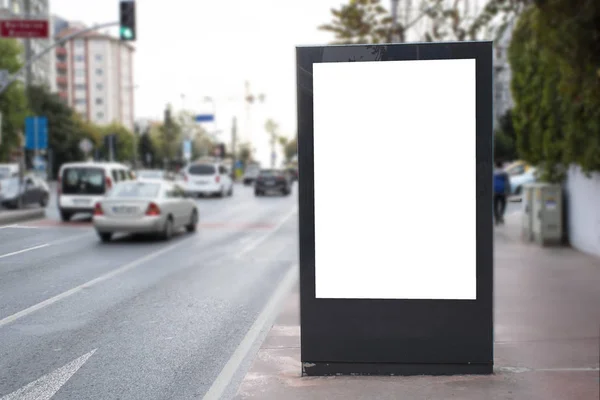 Yol kenarındaki boş beyaz dikdörtgen reklam panosu.