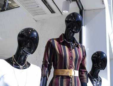 Siyah cansız manken. Giysileri var. Plastikten yapılmış.