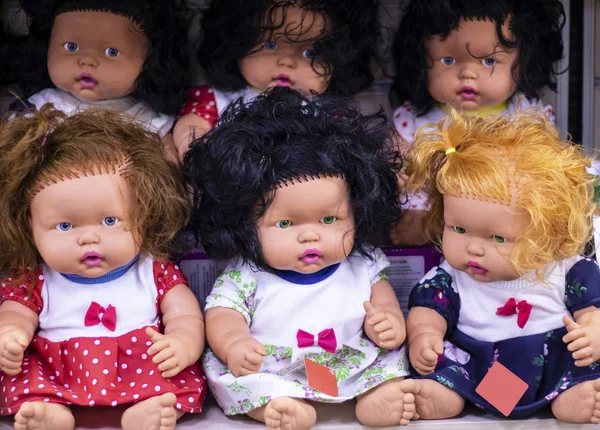 Colorful eyed baby with plastic hair sold outside in front of store for girls. — ストック写真