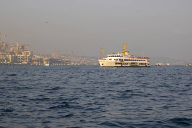 Buharlı gemi gün batımında Boğaz 'da denizde çekilmiş. Geminin arkasında İstanbul şehri var..