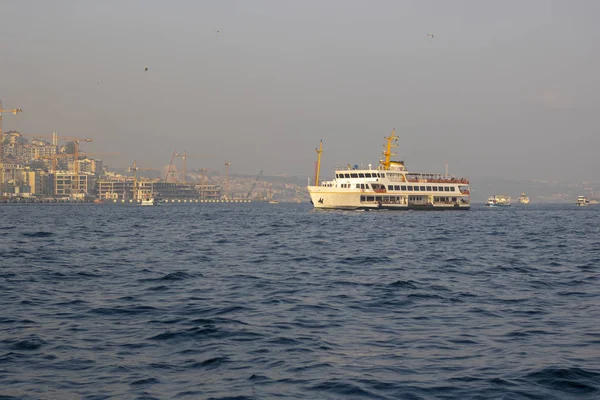Bateau à vapeur photographié au coucher du soleil sur la mer dans le Bosphore. Derrière le navire se trouve la ville d'Istanbul . — Photo
