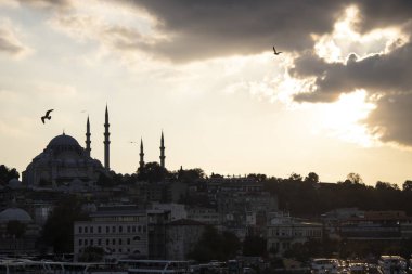 Bulutlu havada Süleyman Camii ve Eminonu kıyıları. Kızarmış balık satan tekneler ve etrafta dolaşan insanlar. Akşama doğru çekilmiş..