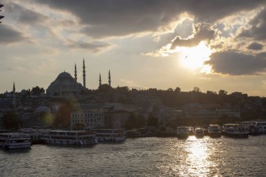 Bulutlu havada Süleyman Camii ve Eminonu kıyıları. Kızarmış balık satan tekneler ve etrafta dolaşan insanlar. Akşama doğru çekilmiş..