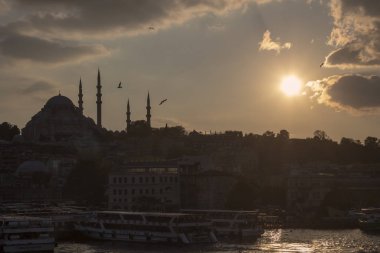 Bulutlu havada Süleyman Camii ve Eminonu kıyıları. Kızarmış balık satan tekneler ve etrafta dolaşan insanlar. Akşama doğru çekilmiş..