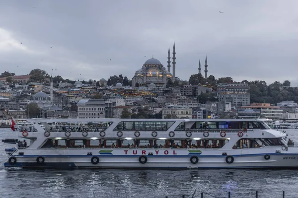 Meczet Suleymaniye i wybrzeże Eminonu w pochmurną pogodę. Łodzie sprzedające smażone ryby i ludzie chodzący dookoła. Sfotografowany pod wieczór.. — Zdjęcie stockowe