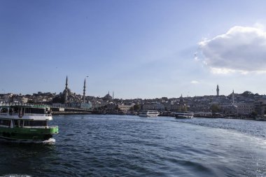Eminonu sahili ve solda yeşil yolcu gemisi. Bulutların gölgesindeki yansımalar. Güneşli güve havada filme alındı..