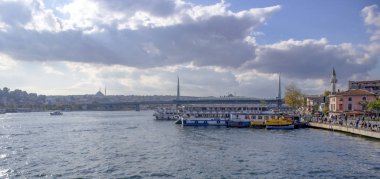 Karaköy sahilinde tekneler ve arka planda Halic Metro Köprüsü.