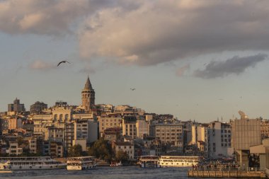 Galata Kulesi ve Galata Köprüsü birlikte ele geçirildi. Galata Köprüsü 'nde balık tutan insanlar. Gün batımında çekilen.