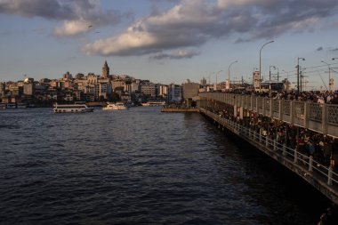 Galata Kulesi ve Galata Köprüsü birlikte ele geçirildi. Galata Köprüsü 'nde balık tutan insanlar. Gün batımında çekilen.