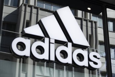 Cam pencere pervazına Adidas işareti asılmış. Yakın plan. Fotoğraf kontrastlı olarak çekildi. Masa adidas adı ve logoyu siyah ve beyaz olarak yazar.