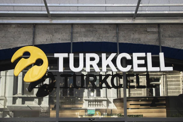 Turkcell es una institución que presta servicios en el campo de las telecomunicaciones. Fue fundada en los años 90. El vidrio tiene un logotipo gris de Turkcell y un reflejo de la ciudad . — Foto de Stock