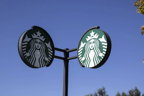 Starbucks sign at Starbucks Coffee Shop. Starbucks is an American global coffee company and coffeehouse chain sold around the world. Sunny sky — Stock Photo, Image