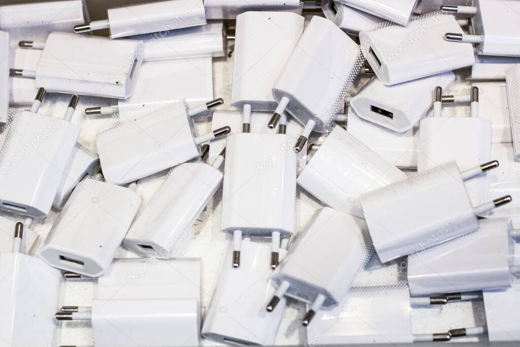 White usb charging heads close-up. There are a lot of them.