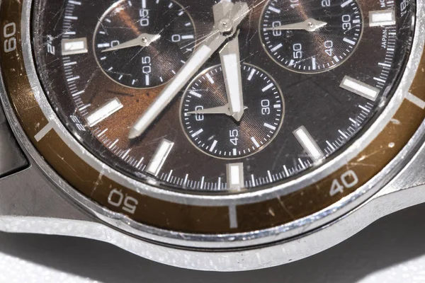 Close-up of a used wristwatch. The outer case is metallic and the inside is brown. Macro — Stock Photo, Image