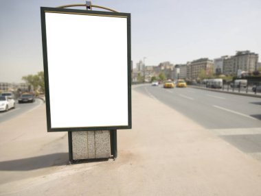 Dikdörtgen beyaz renkli reklam panosu. Yolun kenarında duruyor. Ben...