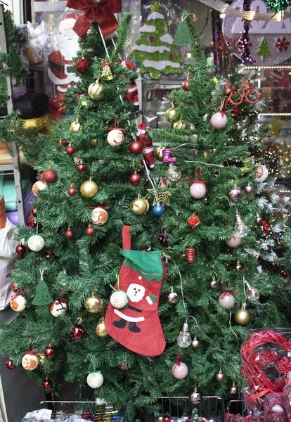 Decorative Christmas decorations close-up. Hanging ornaments on the fake pine tree. There are colored balls on it. — 图库照片