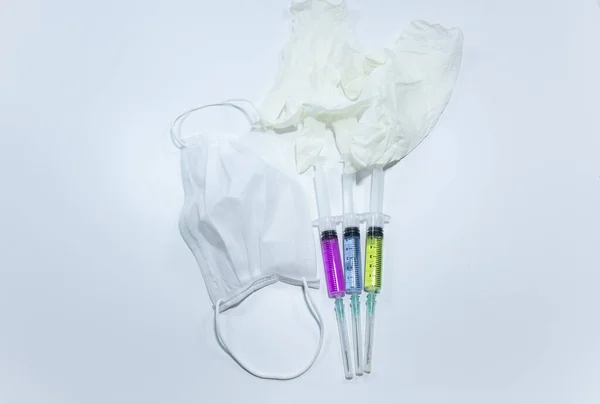 3色の液体と口マスク 注射器の手袋 スタジオで撮影され 白い背景 — ストック写真