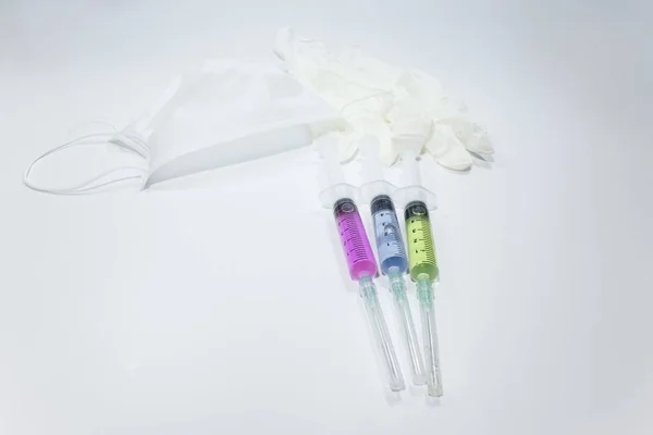 3色の液体と口マスク 注射器の手袋 スタジオで撮影され 白い背景 — ストック写真