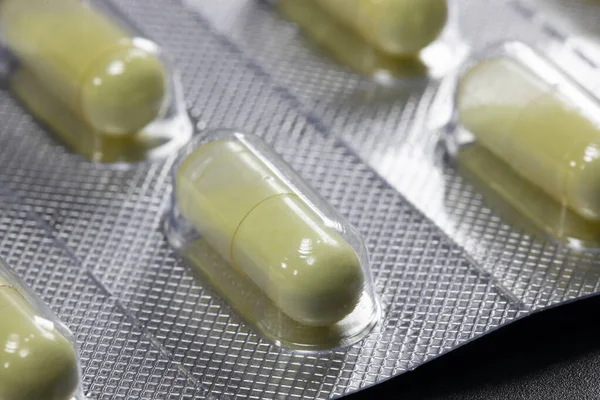 Żółte Okrągłe Tabletki Opakowaniu Czarnym Tle Zbliżenie — Zdjęcie stockowe