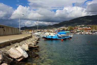 Altinoluk, Türkiye -15 Mart 2016: Altinoluk limanında küçük balıkçı tekneleri ve yatlar. Kıyıdaki turist kafe restoranları..