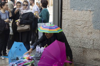 İstanbul, Türkiye - Kasım 05.2019: Sokaklarda yeni şemsiye satan bir adama yakın çekim. Pek çok renk ve çeşitlilik var. Adam duvarın yanında ve etrafında..
