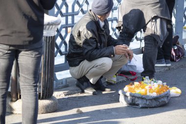 İstanbul, Türkiye - Kasım-02: 2019: Limon suyu sıkmak için makine satan eski bir satıcı. İnsanlar ağzında sigara olan adamı elden ele gezdiriyorlar..