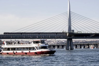 İstanbul, Türkiye - Kasım 05.2019: Soldan yolcu feribotu ve arkada Haliç köprüsü. Metro köprüyü geçiyor..