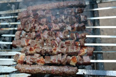 Şişlerin üzerinde kırmızı et parçaları var. Dumanlı, alevli ve lezzetli görünüyor. Sağlıklı yiyecekler. İstanbul, Türkiye.