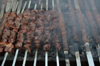 Şişlerin üzerinde kırmızı et parçaları var. Dumanlı, alevli ve lezzetli görünüyor. Sağlıklı yiyecekler. İstanbul, Türkiye.