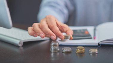 El, sikkeler, hesap makinesi, günlük, kalem.