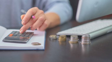 El, sikkeler, hesap makinesi, günlük, kalem.