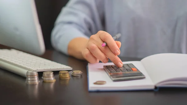 El, sikkeler, hesap makinesi, günlük, kalem.