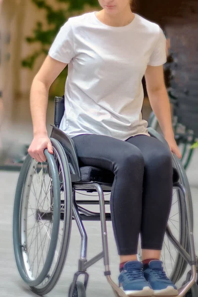 Minsk, Belarus, 29 Şubat 2020 - Gönüllü eğitmen, şehirde tekerlekli sandalyedeki basamakları ve kaldırımları aşma tekniğini gösteriyor.